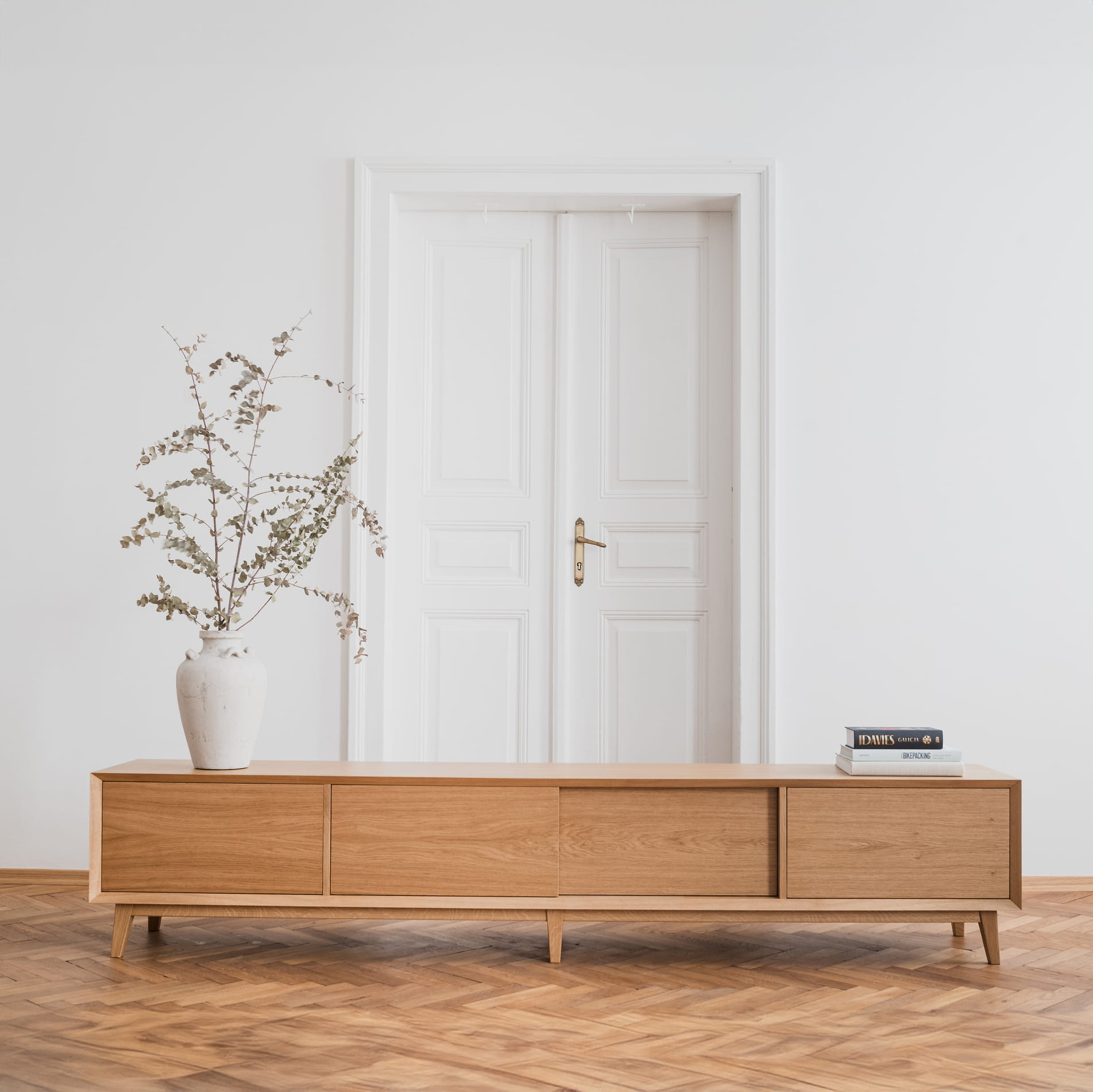 Sideboard Helsingør II z naturalnego dębu, widok na całą bryłę na tle jasnej ściany, KOS Design